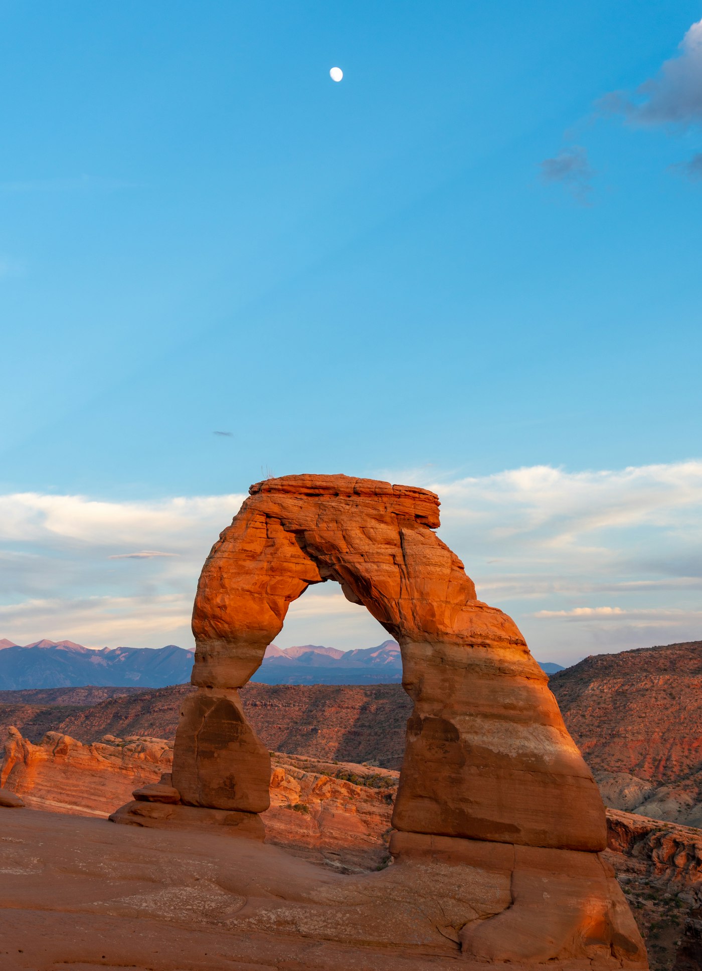 Delicate Arch with the moon overhead in Arches National Park, Utah